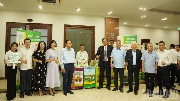 Các đại biểu chụp ảnh tại gian hàng trưng bày các sản phẩm phân bón.