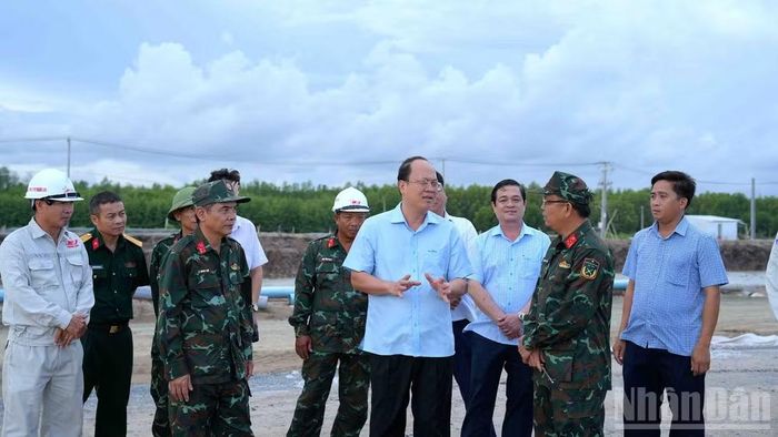 Bí thư Tỉnh ủy Cà Mau Nguyễn Hồ Hải (đứng giữa, đeo kính) trò chuyện cùng đội ngũ chủ chốt ngày đêm bám công trường tại chuyến kiểm tra thực tế vào chiều muộn 16/6.