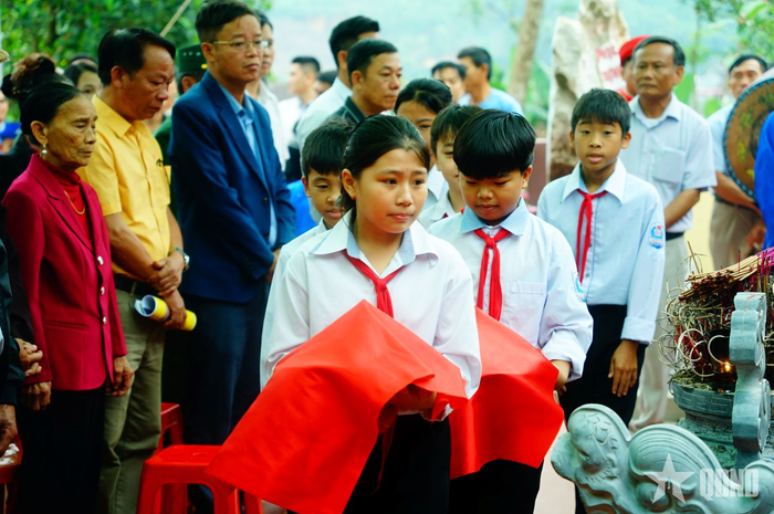 Các cháu thiếu nhi rước đất và nước lấy từ đại bản doanh cuộc khởi nghĩa năm xưa về thờ tại đền. 