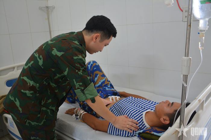 Bác sĩ, Đại úy Nguyễn Đình Khanh thăm, khám cho Hạ sĩ Tạ Đức Long.