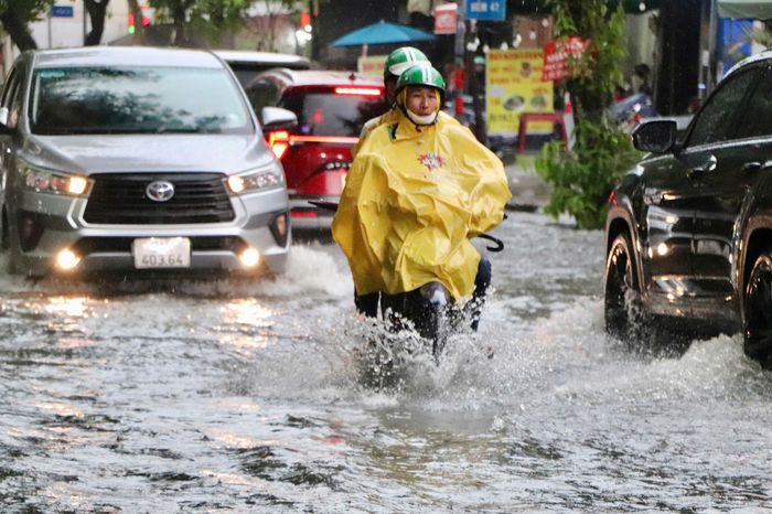 Với tài xế xe ôm công nghệ, việc di chuyển giữa màn mưa ngập thêm phần khó khăn 