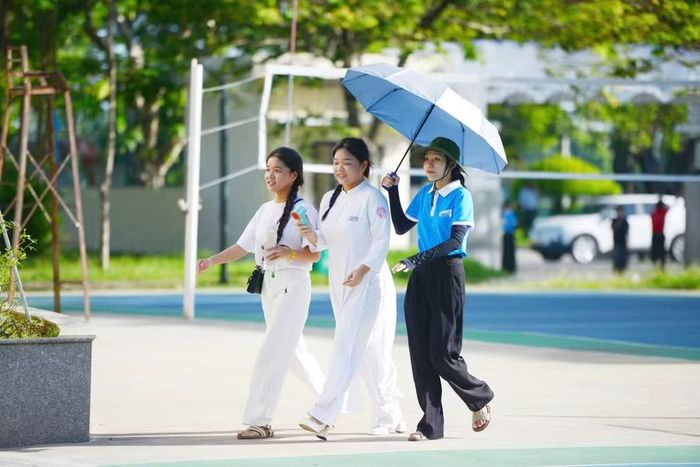 Tình nguyện viên che dù cho thí sinh đến các phòng thi.