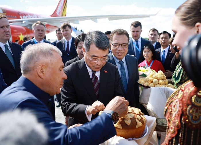 Lãnh đạo Cộng hòa Tatarstan mời Thủ tướng Lê Minh Hưng ăn bánh mì muối và kẹo ngọt theo nghi thức truyền thống đón khách quý của địa phương. Ảnh: TTXVN