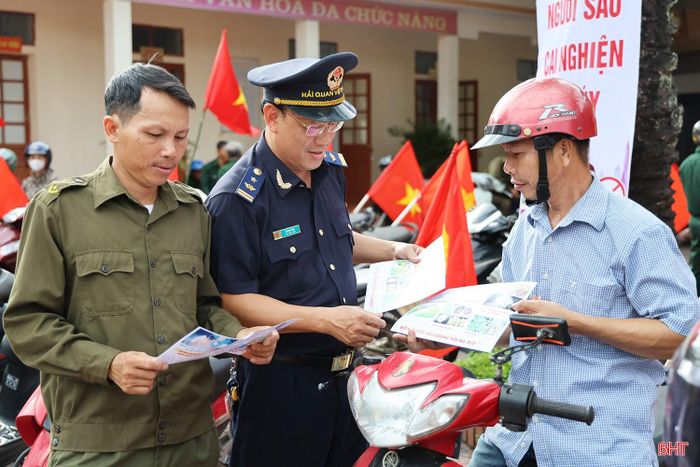 Cán bộ Chi cục Hải quan khu vực XI phát tờ rơi tuyên truyền phòng, chống ma túy cho người dân xã Sơn Kim 1.