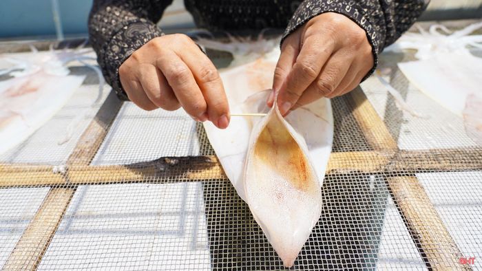 Sau đó tôi tiếp tục chỉnh phần đầu, phần diềm để mực giữ được dáng đẹp và khô đều. Muốn mực đạt chuẩn thì đầu, thân và diềm phải khô như nhau, không cong, không đứt.