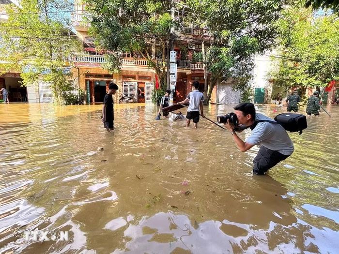 Phóng viên Nguyễn Quang Cường, Cơ quan thường trú tại tỉnh Tuyên Quang (TTXVN), tác nghiệp tại phường Minh Xuân, thời điểm cơn bão số 10 gây ảnh hưởng. (Nguồn: TTXVN)