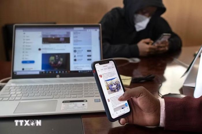 Người dân theo dõi thông tin trên điện thoại di động ở Thika, Kenya. (Ảnh: AFP/TTXVN)