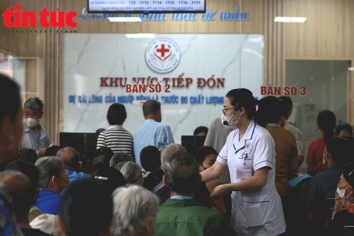 Chị Trương Thị Hồng, Điều dưỡng trưởng Khoa Khám bệnh đang hướng dẫn người dân thủ tục khám bệnh.
