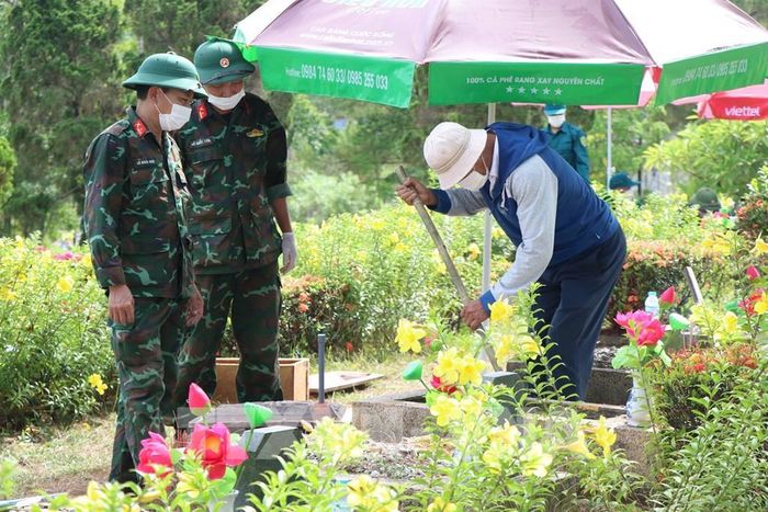 Lấy mẫu hài cốt liệt sĩ tại Nghĩa trang Liệt sĩ thành phố Huế. Ảnh: Mai Trang - TTXVN