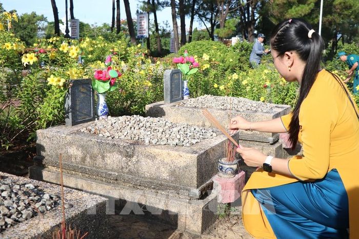 Thắp hương tri ân các phần mộ liệt sĩ tại Nghĩa trang Liệt sĩ thành phố Huế. Ảnh: Mai Trang - TTXVN