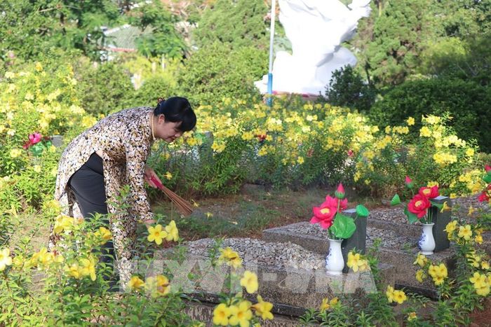 Thắp hương tri ân các phần mộ liệt sĩ tại Nghĩa trang Liệt sĩ thành phố Huế. Ảnh: Mai Trang - TTXVN