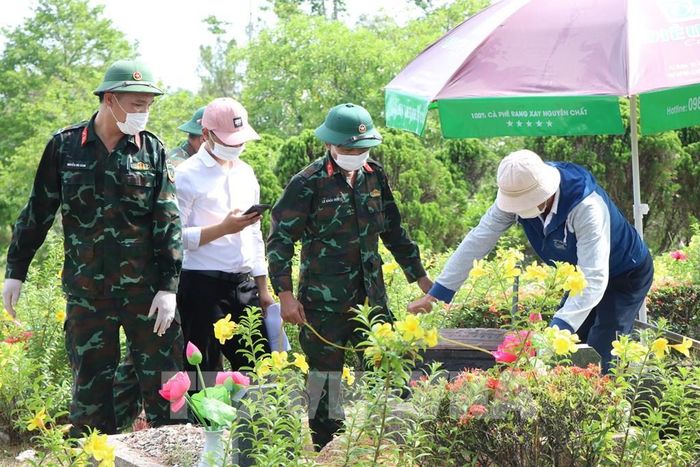 Lấy mẫu hài cốt liệt sĩ tại Nghĩa trang Liệt sĩ thành phố Huế. Ảnh: Mai Trang - TTXVN