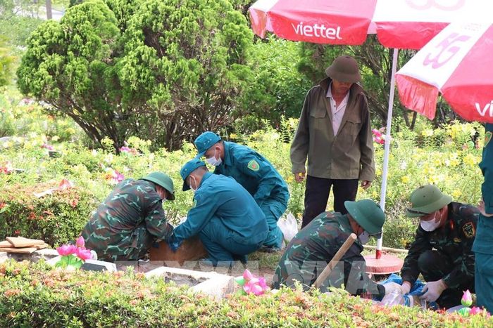 Lấy mẫu hài cốt liệt sĩ tại Nghĩa trang Liệt sĩ thành phố Huế. Ảnh: Mai Trang - TTXVN