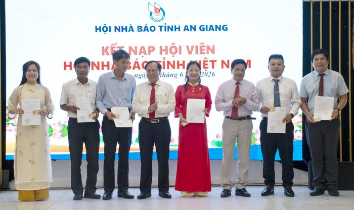 Chủ tịch Hội Nhà báo tỉnh An Giang Tân Văn Ngữ (thứ tư, từ trái qua) và Phó Chủ tịch Thường trực Hội Nhà báo tỉnh An Giang Đoàn Hồng Phúc (thứ ba, từ phải qua) trao quyết định công nhận và thẻ hội viên Hội Nhà báo Việt Nam cho hội viên mới. Ảnh: TRƯƠNG MINH ĐIỀN