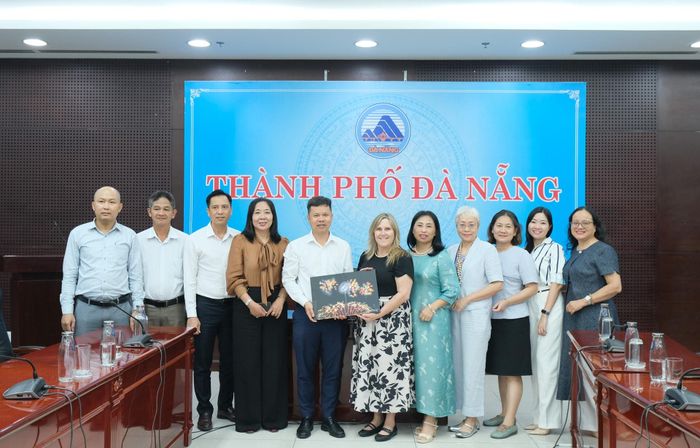 Đại diện UBND thành phố tặng quà lưu niệm cho bà Morgan Hugh Lance (thứ 6, từ phải qua). Ảnh: TÂM ĐAN