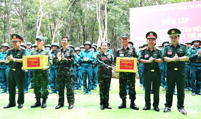 Thủ trưởng Quân khu 7, Bộ Chỉ huy Quân sự thành phố và xã Tân Tiến tặng quà các lực lượng diễn tập. Ảnh: Nguyệt Hà