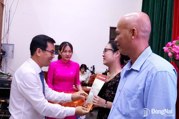 Phó Bí thư Thường trực Đảng ủy phường Long Thành Nguyễn Sang tặng quà chúc mừng các nhà báo. Ảnh: Nguyệt Hà
