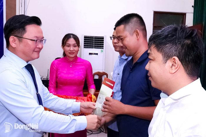 Thành ủy viên, Bí thư Đảng ủy, Chủ tịch HĐND phường Long Thành Nguyễn Hữu Nguyên tặng quà chúc mừng các nhà báo. Ảnh: Nguyệt Hà