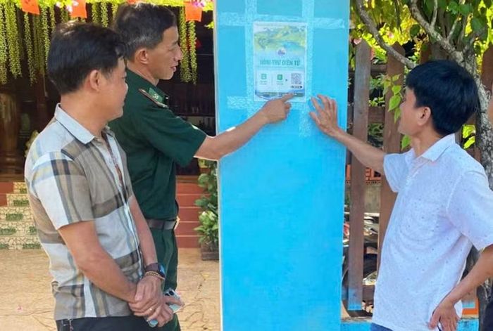  Cán bộ Đồn Biên phòng Ia Nan hướng dẫn người dân sử dụng “Hòm thư điện tử tiếp nhận tin báo, tố giác tội phạm” thông qua mã QR. Ảnh: N.T 