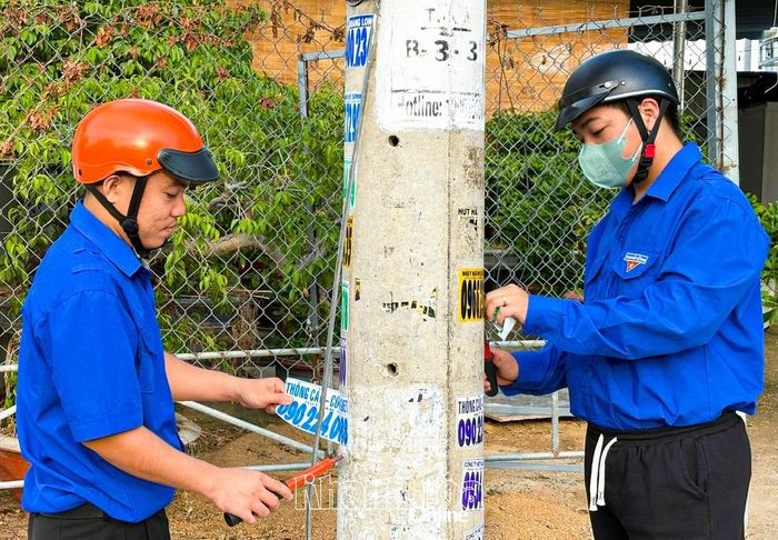 Thanh niên phường Cam Ranh ra quân tẩy xóa quảng cáo sai quy định.