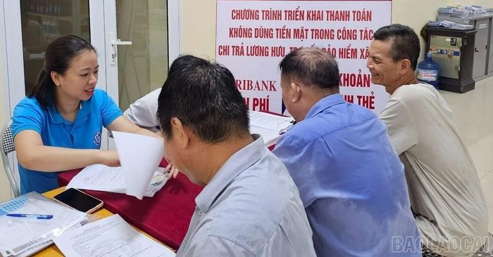 Cán bộ bảo hiểm xã hội tư vấn chi trả lương hưu, trợ cấp bảo hiểm xã hội qua tài khoản ngân hàng.