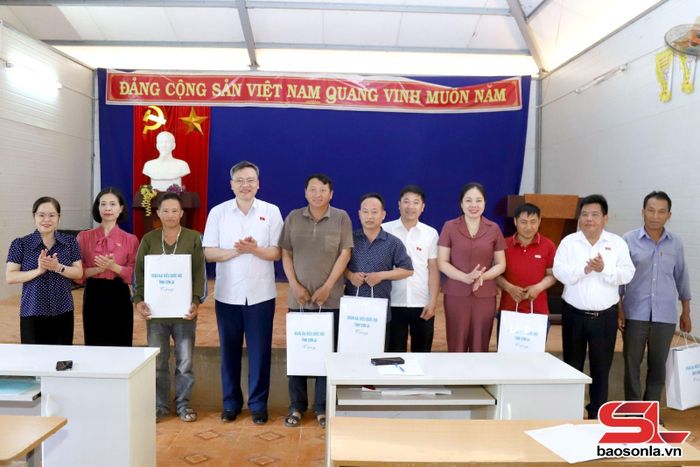 Đoàn đại biểu Quốc hội tỉnh tặng quà cho các hộ dân bản Pá Lâu, xã Bó Sinh.