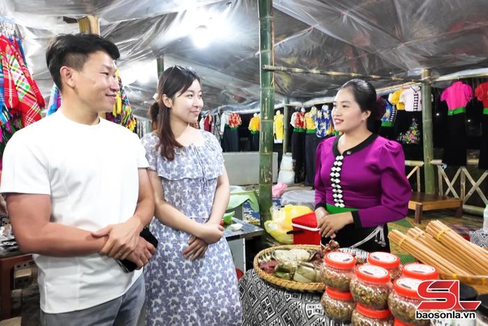 Người dân giới thiệu sản phẩm du lịch và đặc sản địa phương tới du khách.