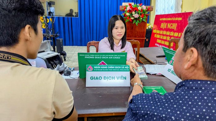 Anh L.V.L. và cha ruột đến ngân hàng nhận gói vay hỗ trợ để về thực hiện mô hình nuôi ếch thịt. Ảnh: Nghiêm Túc