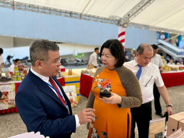 Chủ tịch Liên minh HTX Việt Nam Cao Xuân Thu Vân và các đại biểu trao đổi về sản phẩm của HTX.