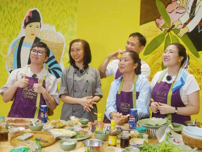 Các nhà sáng tạo nội dung nghe chuyên gia ẩm thực tại Saigon Cooking Class hướng dẫn trước khi thực hành làm bánh xèo và gỏi cuốn.