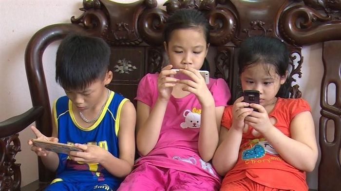 Việc cha mẹ cho con sử dụng điện thoại, máy tính bảng quá nhiều trong kỳ nghỉ hè để tiện trông nom có thể gây ra nhiều tác động tiêu cực đến tinh thần của trẻ. Ảnh minh họa