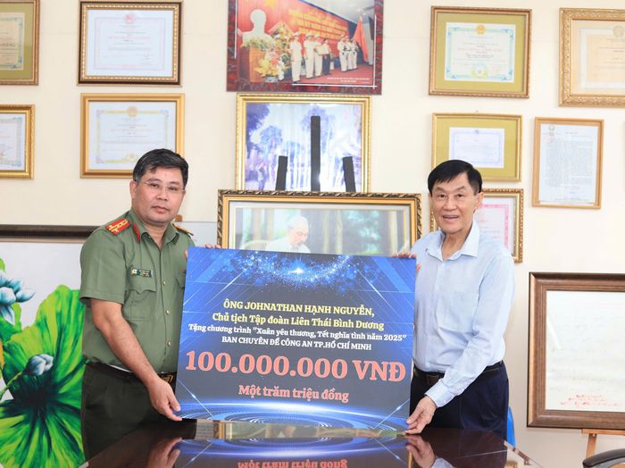 Ông Johnathan Hạnh Nguyễn trao 100 triệu đồng cho Đại tá Bùi Ngọc Giáp, Trưởng Ban Chuyên đề Công an TPHCM để tặng quà cho người dân khó khăn