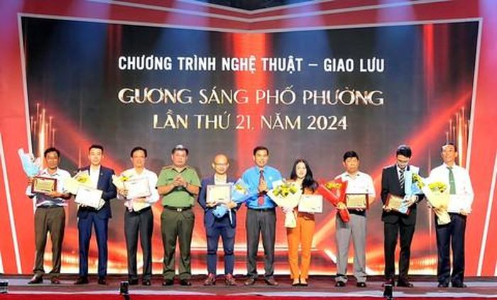 Đại tá Bùi Ngọc Giáp, Trưởng Ban Chuyên đề Công an TPHCM và ông Giang Văn Nam - Giám đốc Cung Văn hóa Lao động TPHCM tặng Kỷ niệm chương và tặng hoa tri ân các nhà tài trợ Chương trình giao lưu “Gương sáng phố phường” lần thứ 21, tổ chức năm 2024.