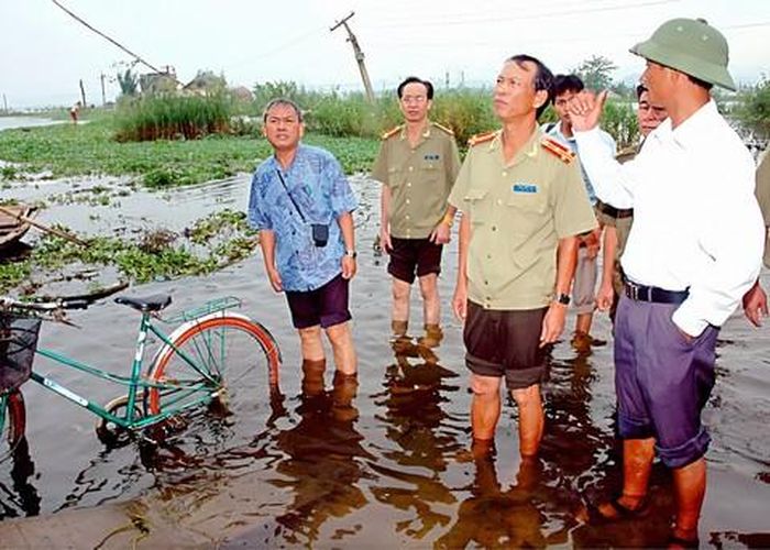 Tổng Biên tập Đặng Xuân Dũng (đứng giữa) và đoàn công tác Báo Công an TPHCM trong chuyến cứu trợ đồng bào bị lũ lụt ở huyện Nho Quan, tỉnh Ninh Bình (năm 2007)