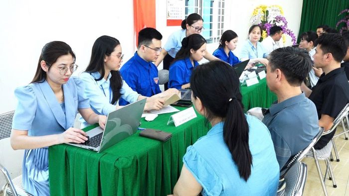 Cán bộ xã giúp người dân giải quyết thủ tục hành chính ngay tại thôn. Ảnh: DH.