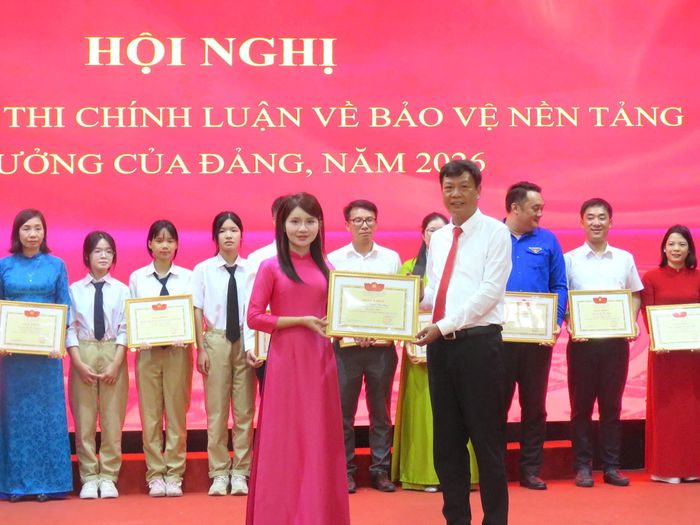 Lãnh đạo Đảng ủy xã khen thưởng thí sinh đạt giải Nhất cuộc thi. Ảnh: Tú Linh.