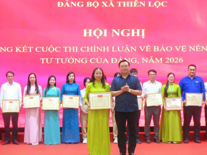 Lãnh đạo Đảng ủy xã khen thưởng thí sinh đạt giải Nhì cuộc thi. Ảnh: Tú Linh.