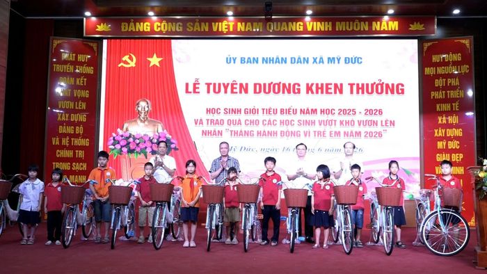 Lãnh đạo xã Mỹ Đức tặng xe đạp cho học sinh vượt khó. Ảnh: Biên Phạm