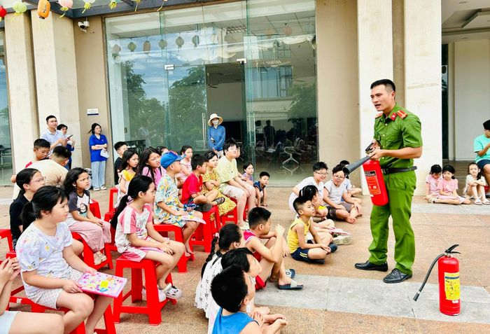 Cán bộ công an phường Hoàng Mai hướng dẫn kỹ năng phòng cháy chữa cháy cho các em nhỏ tại sảnh tòa nhà CT2A – Gelexia. Ảnh: Trần Oanh.