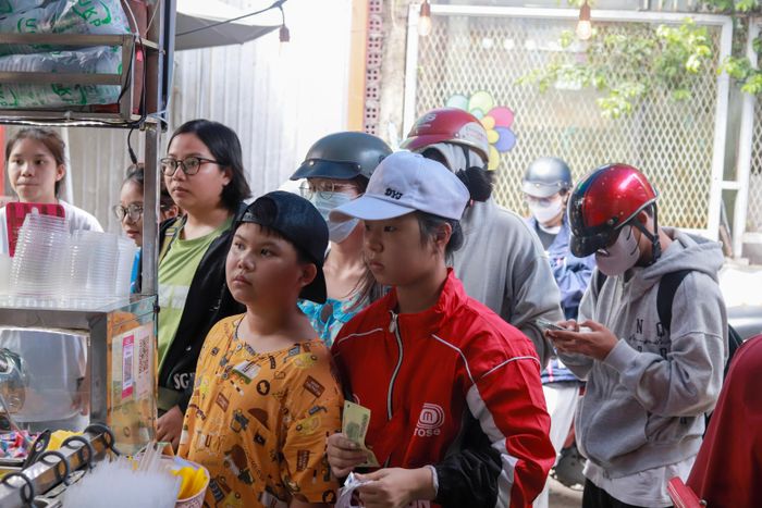  Không khí náo nhiệt vào giờ cao điểm trưa tại quán, khi nhiều bạn trẻ xếp hàng chờ đợi mua đồ uống.
