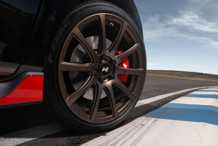 Đi kèm là bộ mâm forged kích thước 18 inch được sơn màu đồng nhám kết hợp với lốp Pirelli P-Zero HN, bên cạnh cùm phanh hiệu năng cao Hyundai N màu đỏ.