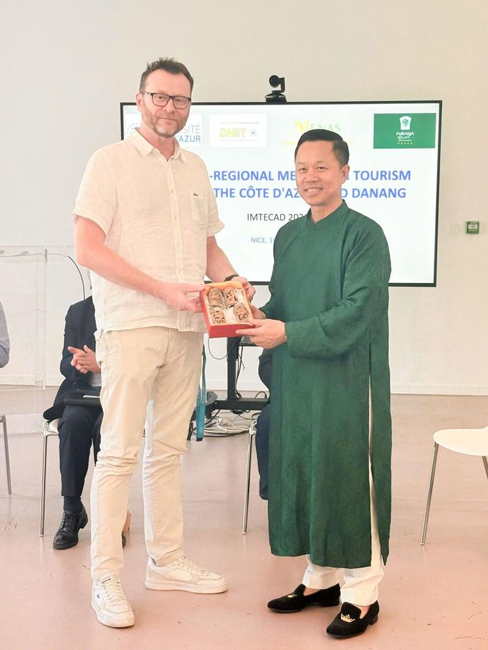 Ông Nguyễn Đức Quỳnh (phải) giới thiệu sản phẩm Quế Trà My điêu khắc đến ông Sylvain Antoniotti tại buổi hội thảo
