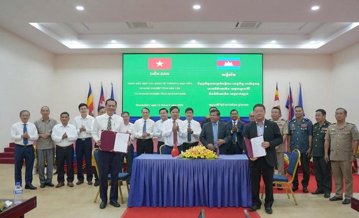 Lãnh đạo hai tỉnh chứng kiến các doanh nghiệp 2 địa phương kí kết biên bản ghi nhớ hợp tác. Ảnh: Hà My