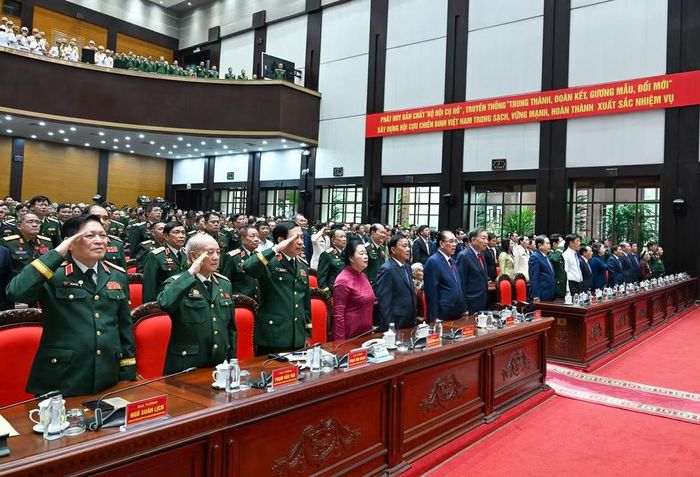 Các đại biểu tham dự Đại hội thực hiện nghi thức chào cờ.