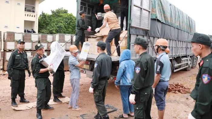 Cán bộ chiến sĩ Công an Lai Châu hỗ trợ bốc dỡ tập kết vật liệu phục vụ thi công Trường nội trú liên cấp Pa Tần.