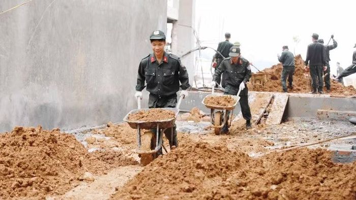 Cán bộ chiến sĩ Công an Lai Châu hỗ trợ vận chuyển đất tại trường nội trú liên cấp Pa Tần.