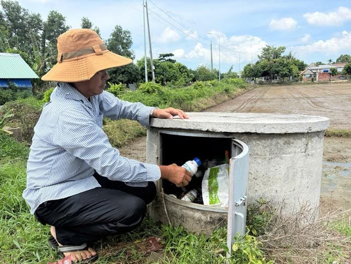 Nông dân xã Long Điền thu gom bao bì thuốc bảo vệ thực vật sau sử dụng để đưa vào bể chứa trên cánh đồng.