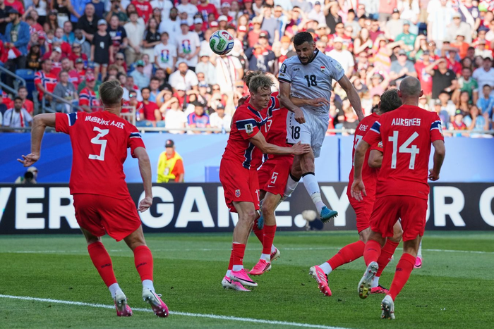 Aymen Hussein bật cao đánh đầu ghi bàn gỡ hòa 1-1 cho Iraq. Ảnh: AP