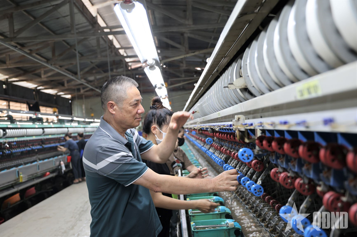 Ông Trần Văn Ba, Giám đốc Công ty TNHH Tơ lụa Hualong Lâm Đồng kiểm tra chất lượng tơ tại nhà máy.