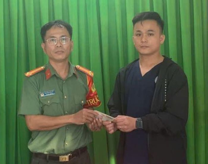 Anh Trường bàn giao số tiền nhặt được cho Công an phường Điện Bàn.